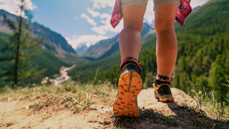 a woman hiking in wilderness on a rugged path