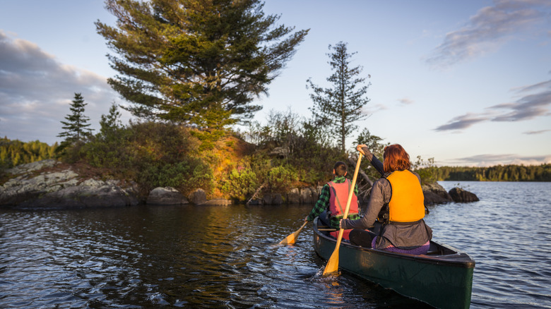 Couple paddling canoe on a Maine lake