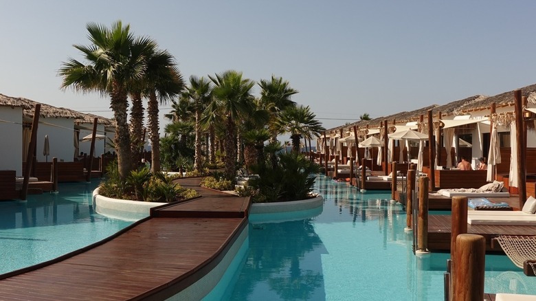 Cabanas in pool with palm trees