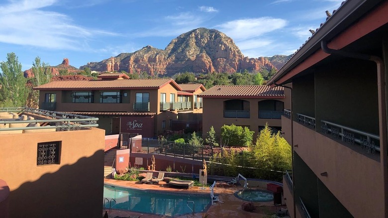 view of the heated pool and outdoor hot tub at Wilde Resort and Spa in Sedona, with large red rocks in the distance
