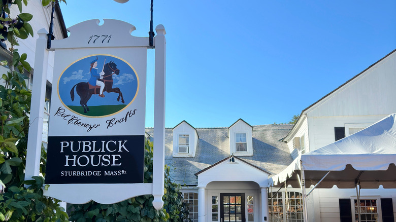 The entrance and sign to the Publick House Inn featuring a painting of builder Col. Ebenezer Crafts.
