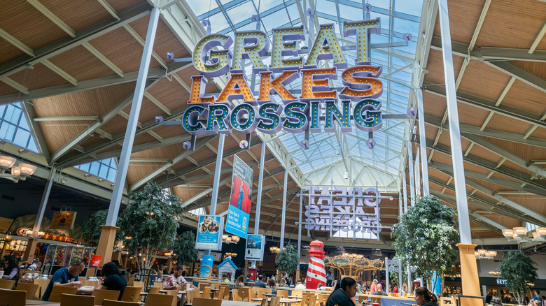 The Great Lakes Crossing foodcourt with the sign, light pouring in the glass ceiling, and a few patrons eating at the many tables