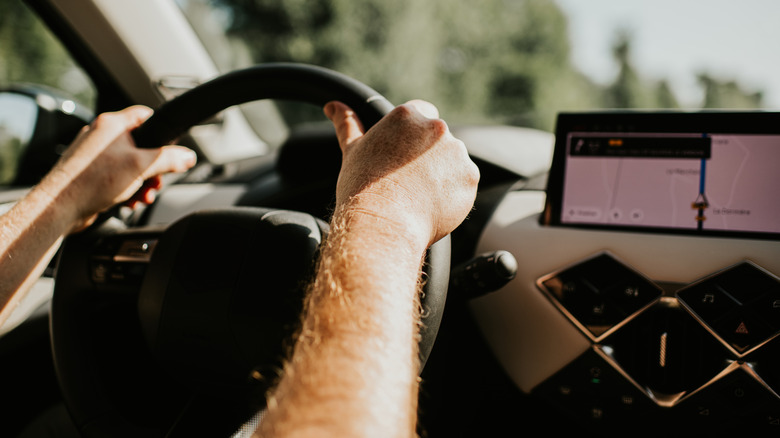 A driver using a built-in car navigation display
