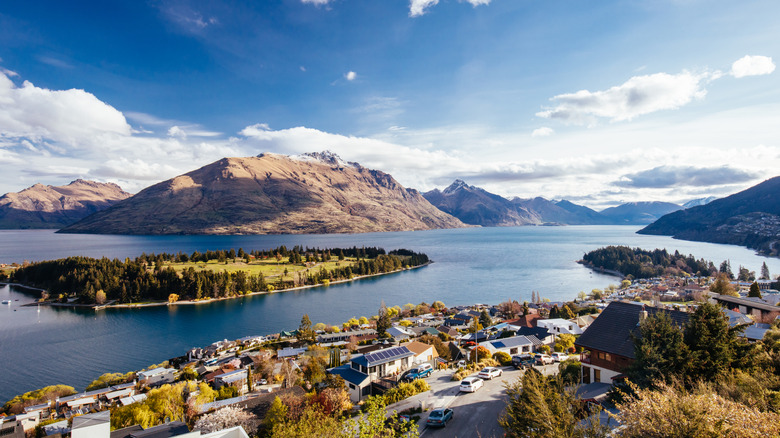 Aerial view of Lake Wakatipu in Queenstown, with town in foreground and mountains behind