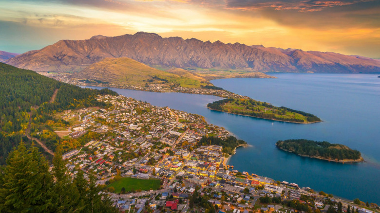 Aerial view of Queenstown at sunset, with mountains in the distance