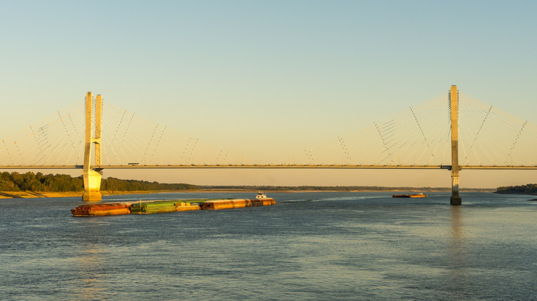 Boat on a river with a bridge over it in Greenville, Mississippi