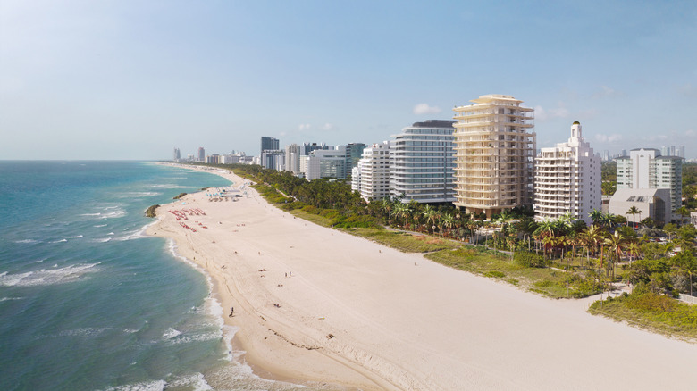 Aerial view of various luxury hotels and residences along Miami Beach's coastline, including the planned Aman Miami Beach residential tower and hotel, in Miami Beach, Florida, USA