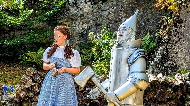 Dorothy holds tin can next to Tin Man, both looking concerned at the Land of Oz
