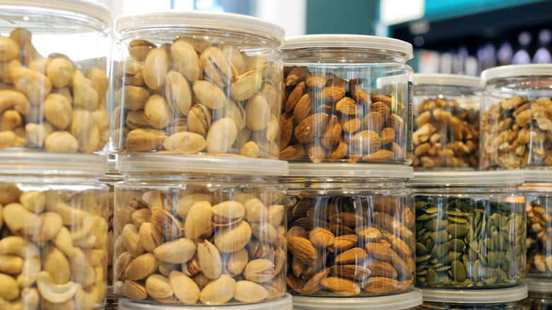A variety of different nuts in jars including pistachio