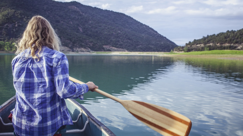 A woman paddles across the waters of Harvey Gap State Park