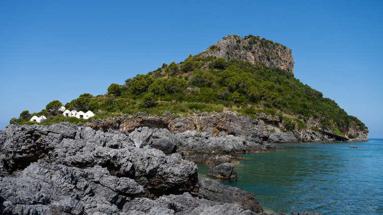 The rocky shores and vegetation of Dino Island, Italy seen from a distance