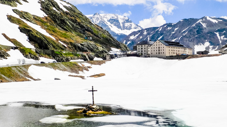 The Grand St-Bernard Hospice next to a lake and mountains at the Swiss-Italian border