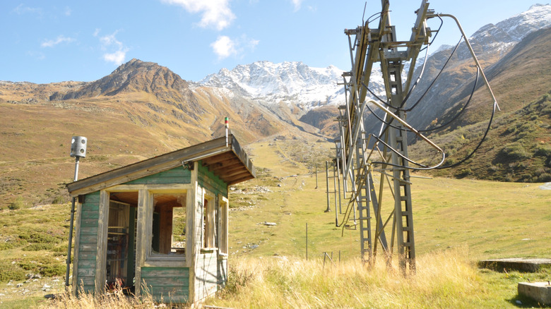 Abandoned ski shack and lift at Super Saint-Bernard in Switzerland with mountainous backdrop