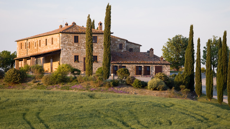 Tuscan villa surrounded by green grass and trees