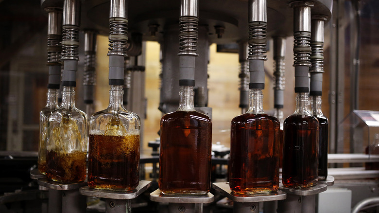 Bottles of bourbon being filled in a distillery