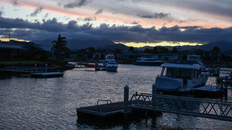 A tranquil marina at dusk, with several boats docked on the water, Whitianga
