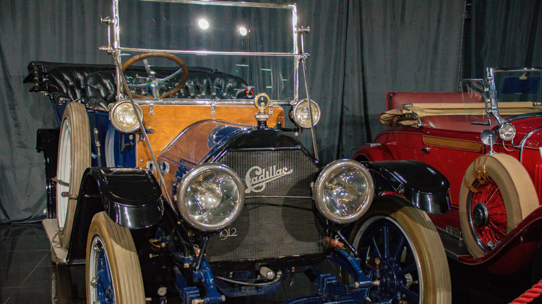 Vintage navy blue Cadillac in showroom.