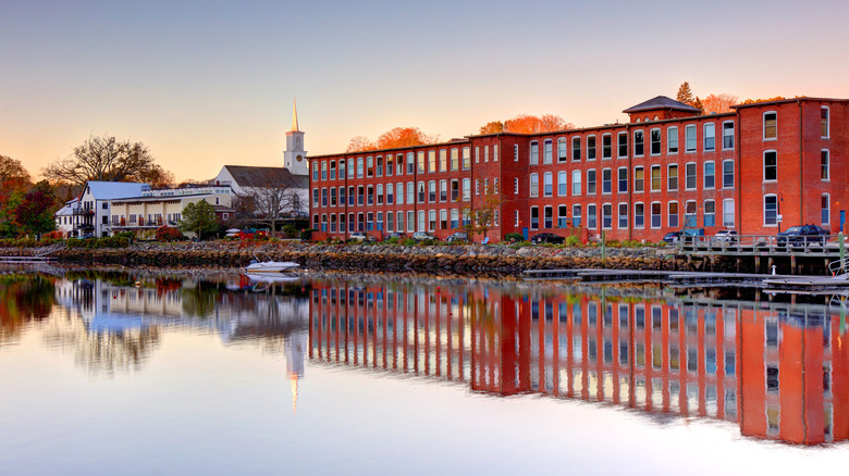 Red historic buildings reflect in Lamprey River, Newmarket, New Hampshire