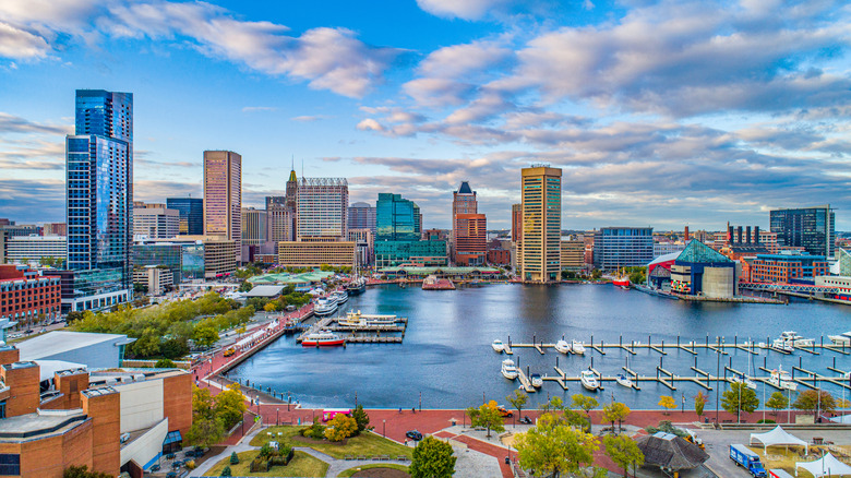 Drone shot of the Inner Harbor promenade with shops, restaurants, and boats on the water in Baltimore, Maryland