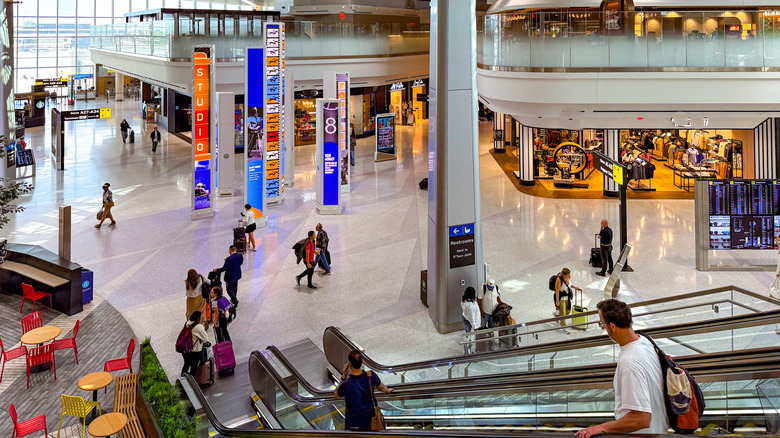 Travelers walk around an airport terminal.