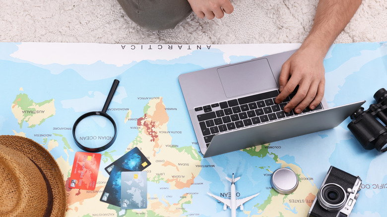A traveler planning a trip with a laptop
