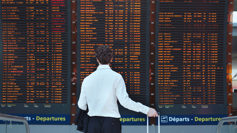 A passenger looks at a flight departures board