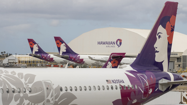 Exterior image of a fleet of aircraft operated by Hawaiian Airlines in front of the hangar and cargo facility at the Daniel K. Inouye International Airport (HNL) in Honolulu, USA