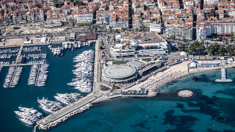 An aerial view of Cannes, specifically the marina, with clear blue water filled with all kinds of boats