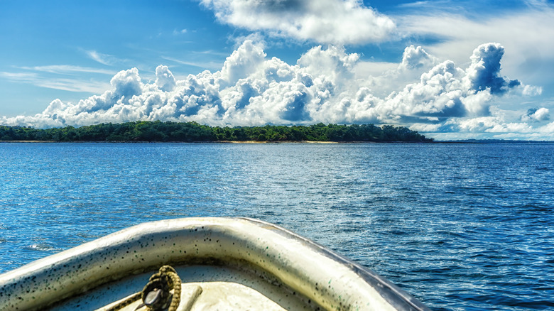 A boat heading towards an island in the Pearl Islands Panama with a beach and jungle