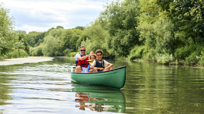 Family of three canoeing down river