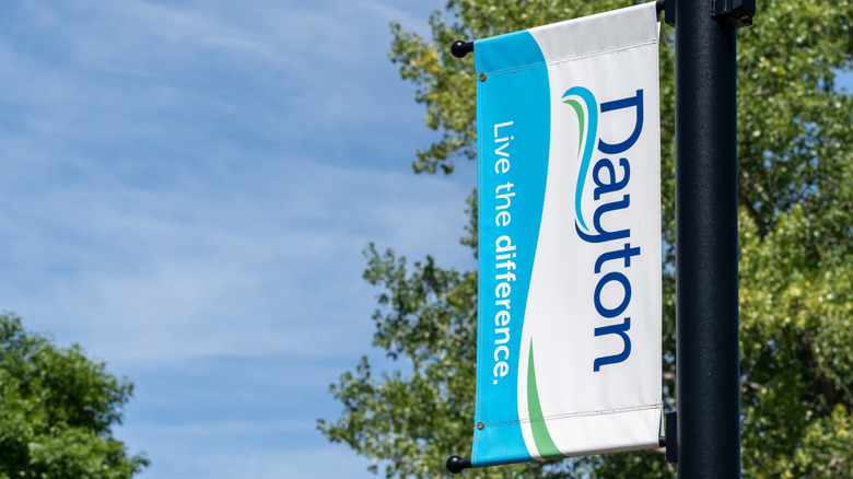Street banner with Dayton written and the slogan "live the difference" on a street pole with trees in the background.