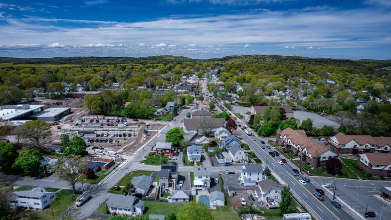 Aerial view of Randolph, Massachusetts during the day with houses, cars, and trees in the background.