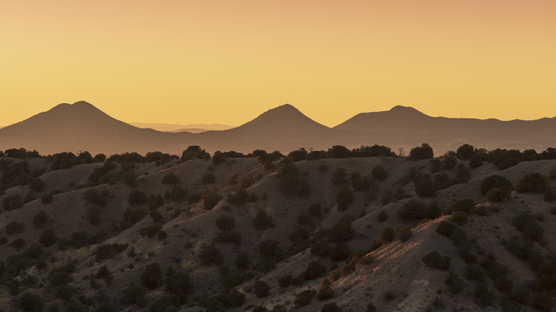 Orange sky at sunset with desert hills and mountains near Galisteo, New Mexico.