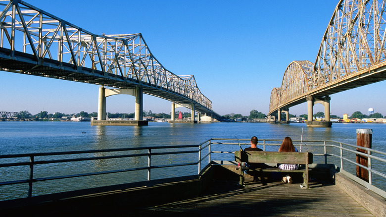 Two people fishing under two bridges
