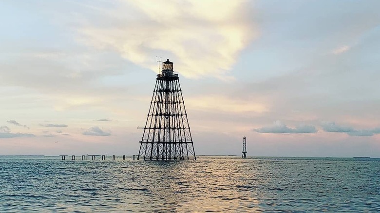 The Sand Key Light on the ocean during sunset.
