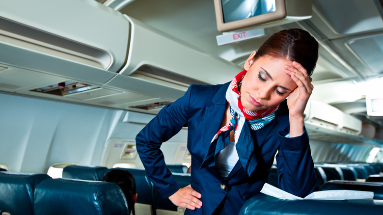 a flight attendant looking irritated and upset