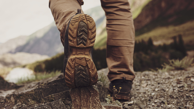Close-up of hiking boots with scenic view in background