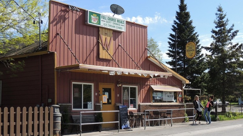 Two women standing outside the Wolfe Island Pub and Pizzeria.