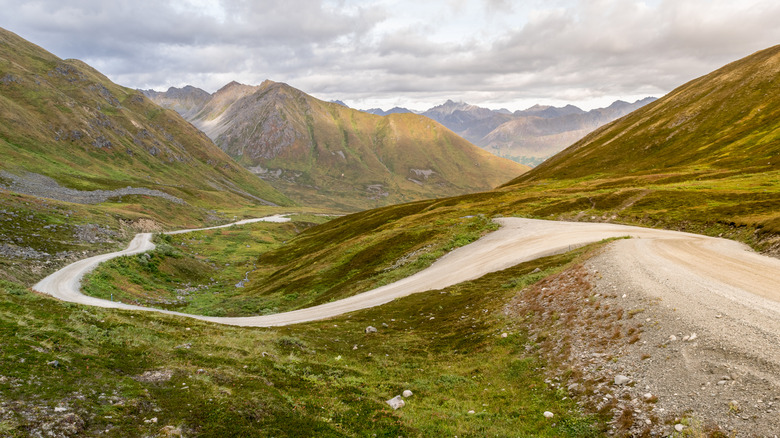 Winding road mountains through rolling hills in Alaska