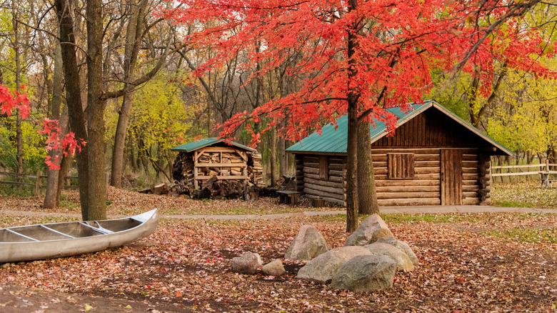 A log cabin and canoe in the woods