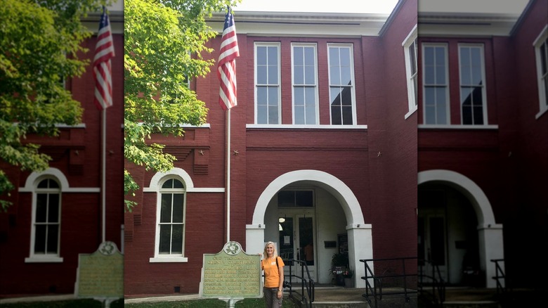 A woman stands at the entrance of the Old Tishomingo County Courthouse Museum