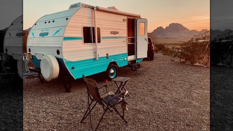 Camper and outdoor seating facing mountains at Rockhound State Park