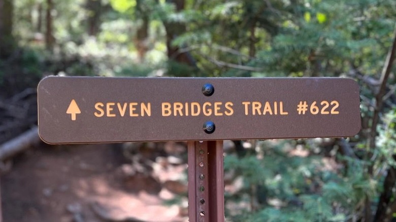 Seven Bridges Trail sign with forest in background