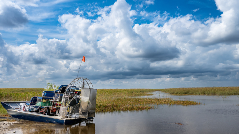 Swamp boat parked on the side of wetlands in the Everglades.