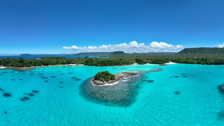 Drone shot of Por Olry Beach and small local islands surrounded by turquoise water
