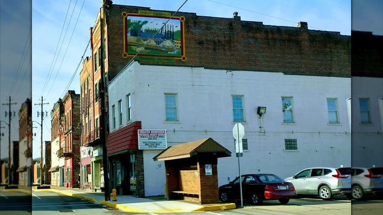 White building in front of brick rowhouses in Monessen, Pennsylvania.