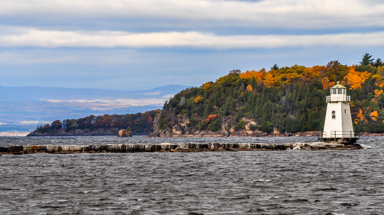 Lake Champlain and small lighthouse with fall colors in background