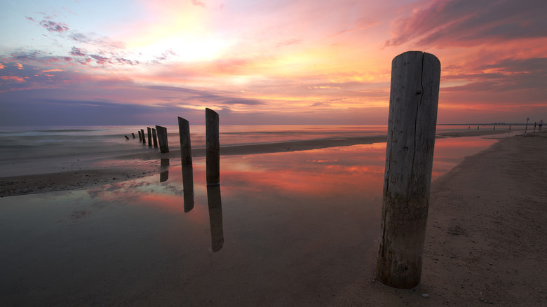 Groynes reflected in water at Sauble Beach, Ontario at sunset