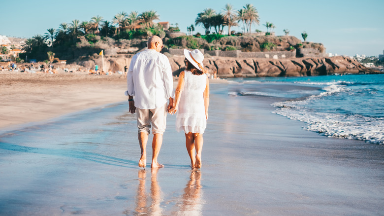 Older couple walking along beach