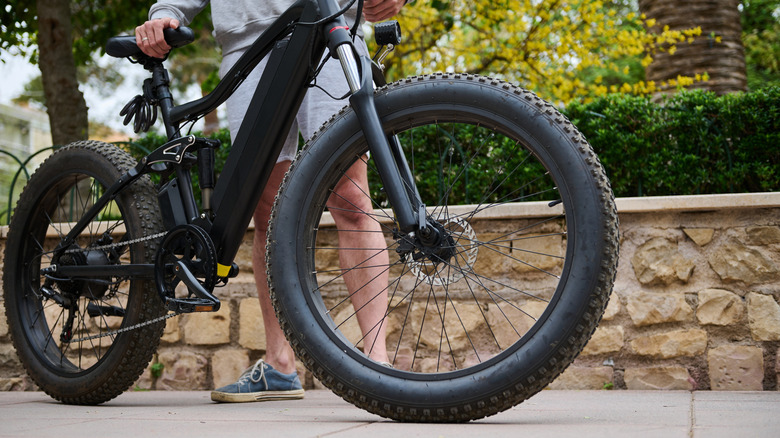 person holding e-bike in city